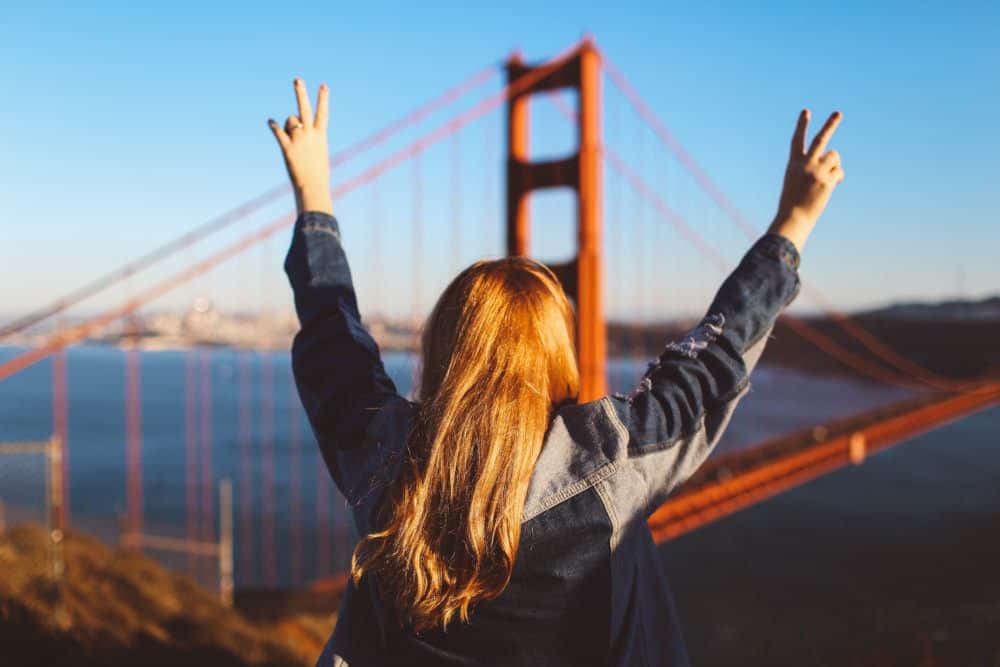 A figure looking out toward the Golden Gate Bridge — wealth as a path to freedom